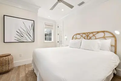 a white bedroom with a large bed and a window at Bella Carriage House in Rosemary Beach