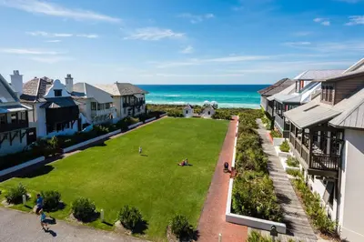 an aerial view of a yard with houses and the ocean at Bella Carriage House in Rosemary Beach