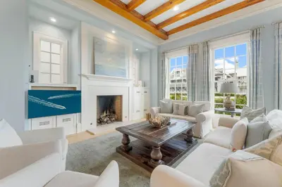 a living room with white furniture and a fireplace at Terra Casa Cottage & Carriage House in Rosemary Beach