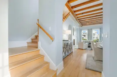 a living room with white walls and a wooden ceiling at Terra Casa Cottage & Carriage House in Rosemary Beach