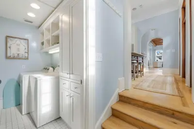 a hallway of a home with white cabinets and a staircase at Terra Casa Cottage & Carriage House in Rosemary Beach