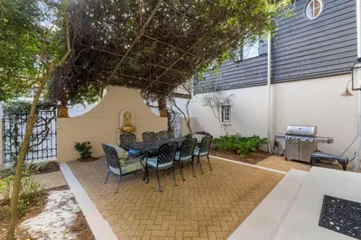 a patio with a table and chairs and a grill at Terra Casa Cottage & Carriage House in Rosemary Beach
