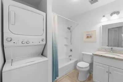 a white bathroom with a tub and a toilet and a sink at Seamist #5 in Seacrest