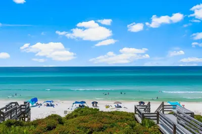 a beach with people in the water and umbrellas at Seamist #5 in Seacrest