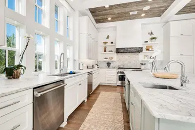 a kitchen with white cabinets and white countertops at 98 Sandy Shores Ct in Seacrest