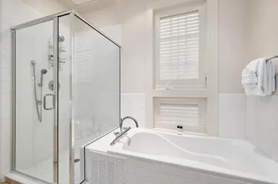 a white bathroom with a tub and a shower at Rose at Mercado in Rosemary Beach