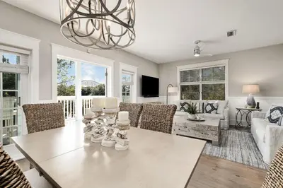 a living room with a table and chairs at Just Breathe Flat in Rosemary Beach