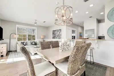 a dining room and living room with a table and chairs at Just Breathe Flat in Rosemary Beach