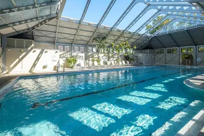 an indoor swimming pool with a glass ceiling at Just Breathe Flat in Rosemary Beach