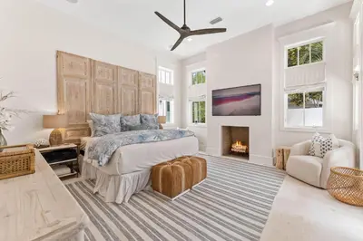 a bedroom with a bed and a fireplace at Moonstruck Cottage and Carriage House in Rosemary Beach
