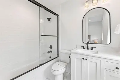 a bathroom with a toilet and a sink and a shower at Moonstruck Cottage and Carriage House in Rosemary Beach