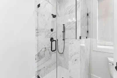 a shower with a glass door in a bathroom at Moonstruck Cottage and Carriage House in Rosemary Beach