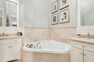 a white bathroom with a tub and two sinks at Joben Cottage in Rosemary Beach