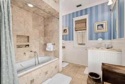 a bathroom with a tub and a sink at Joben Cottage in Rosemary Beach