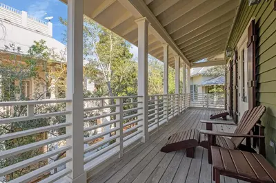 a porch with two benches on a house at Joben Cottage in Rosemary Beach
