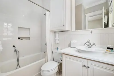 a white bathroom with a sink and a toilet at Joben Cottage in Rosemary Beach