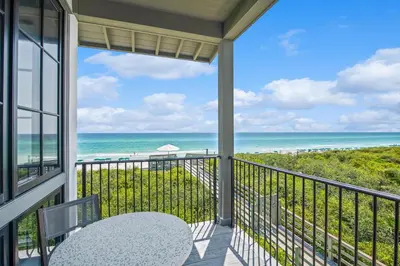 a balcony with a view of the beach at Oasis Cottage & Carriage House in Rosemary Beach