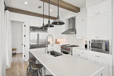 a kitchen with white cabinets and a white counter top at Oasis Cottage & Carriage House in Rosemary Beach
