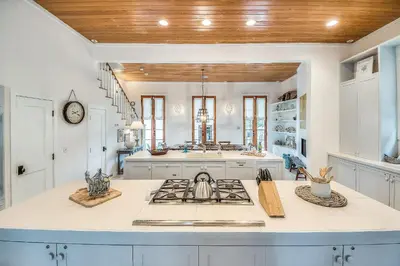 a kitchen with white counters and a stove top oven at Uncorked Cottage in Rosemary Beach