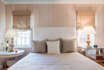 a bedroom with a bed with two tables and two lamps at Uncorked Cottage in Rosemary Beach