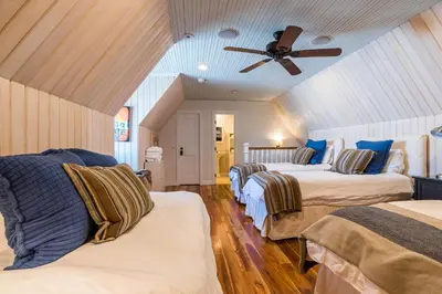 a bedroom with three beds and a ceiling fan at Uncorked Cottage in Rosemary Beach