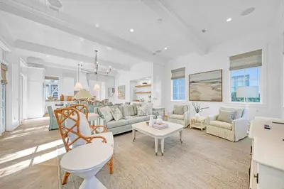a living room with a couch and a table at Deauville Cottage in Rosemary Beach