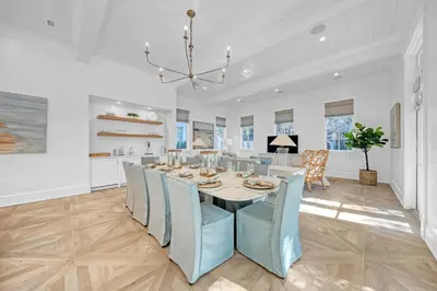 a dining room with a table and blue chairs at Deauville Cottage in Rosemary Beach