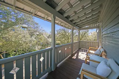 a porch with a couch and chairs on it at Deauville Cottage in Rosemary Beach