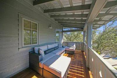 a screened in porch with a couch and a window at Deauville Cottage in Rosemary Beach