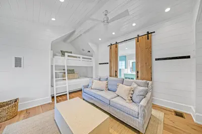 a living room with a couch and a bed at Deauville Cottage in Rosemary Beach