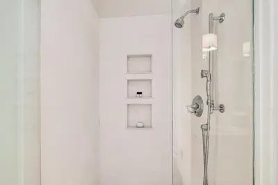 a shower with two shelves in a bathroom at R&B Cottage & Carriage House in Rosemary Beach