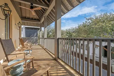 a porch with rocking chairs on a house at R&B Cottage & Carriage House in Rosemary Beach