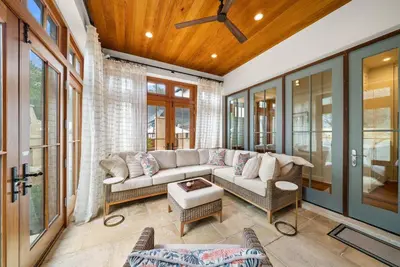 a living room with a couch and some windows at R&B Cottage & Carriage House in Rosemary Beach