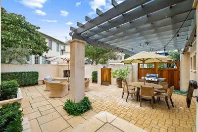 a patio with a table and chairs and an umbrella at R&B Cottage & Carriage House in Rosemary Beach