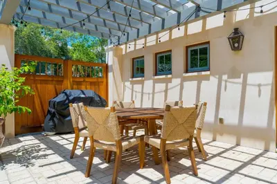 a wooden table and chairs on a patio at R&B Cottage & Carriage House in Rosemary Beach