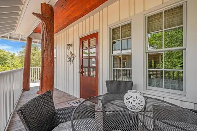 a patio with a table and chairs on a porch at Butterfly Carriage House in Rosemary Beach