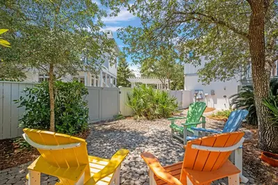 a group of chairs and tables in a yard at Butterfly Carriage House in Rosemary Beach