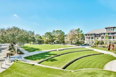 a park with green grass and a building at Butterfly Carriage House in Rosemary Beach