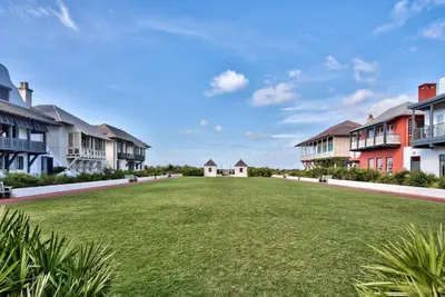a large grassy field in a row of houses at Butterfly Carriage House in Rosemary Beach