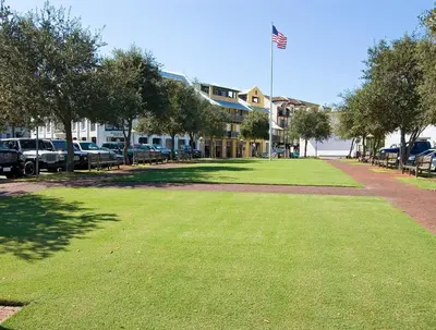 a lawn in front of a building with an american flag at Butterfly Carriage House in Rosemary Beach