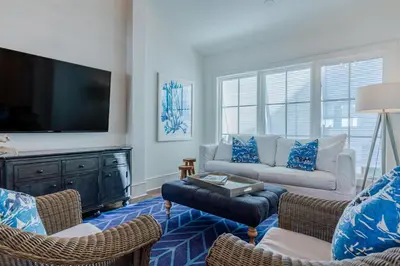 a living room with a couch and a flat screen tv at Kidd Carriage House in Rosemary Beach