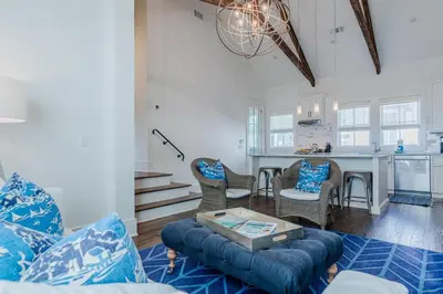 a living room with a couch and a table at Kidd Carriage House in Rosemary Beach
