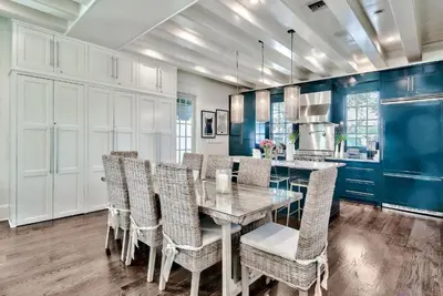 a dining room with a glass table and chairs at Blue Heron Cottage & Carriage House in Rosemary Beach