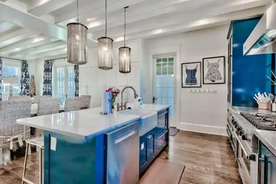 a kitchen with blue cabinets and a blue island at Blue Heron Cottage & Carriage House in Rosemary Beach