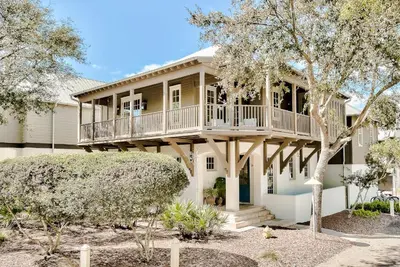 a large house with a porch and a balcony at Blue Heron Cottage & Carriage House in Rosemary Beach