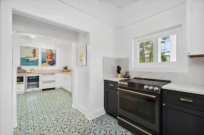 a kitchen with white cabinets and a black stove at Moon Tide in Seacrest
