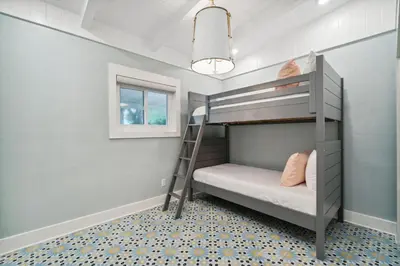 a bunk bed in a small room with a ladder at Moon Tide in Seacrest