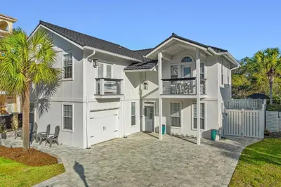 a white house with a palm tree in front of it at Nashvilla in Seacrest