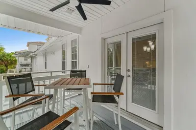 a patio with a table and chairs on a balcony at Nashvilla in Seacrest