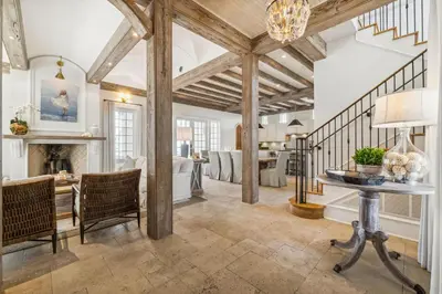 a living room with a table and a fireplace at Water Cottage and Carriage House in Rosemary Beach